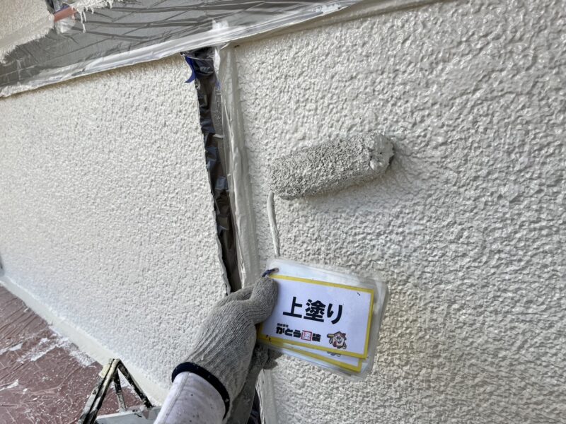 外壁の上塗りの様子です。<br />使用してる「ガイソーウォールフッ素４ＦII」はフッ素樹脂系の最上級塗料で、屋外の過酷な条件でも紫外線や雨風から建物を守ります。